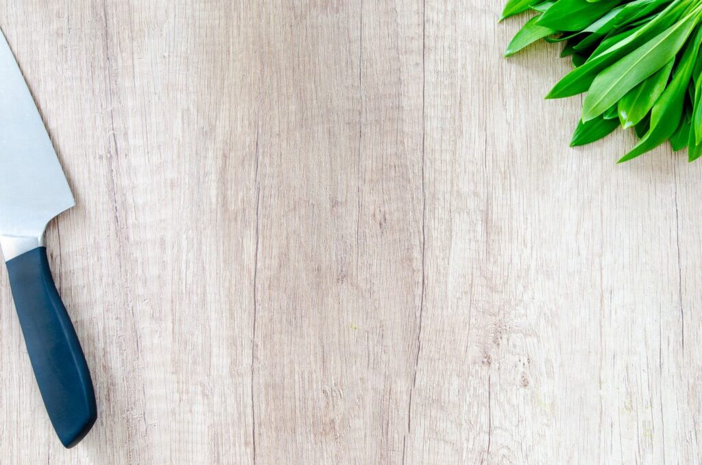 Feuilles vertes fraîchement ciselées sur une planche en bois