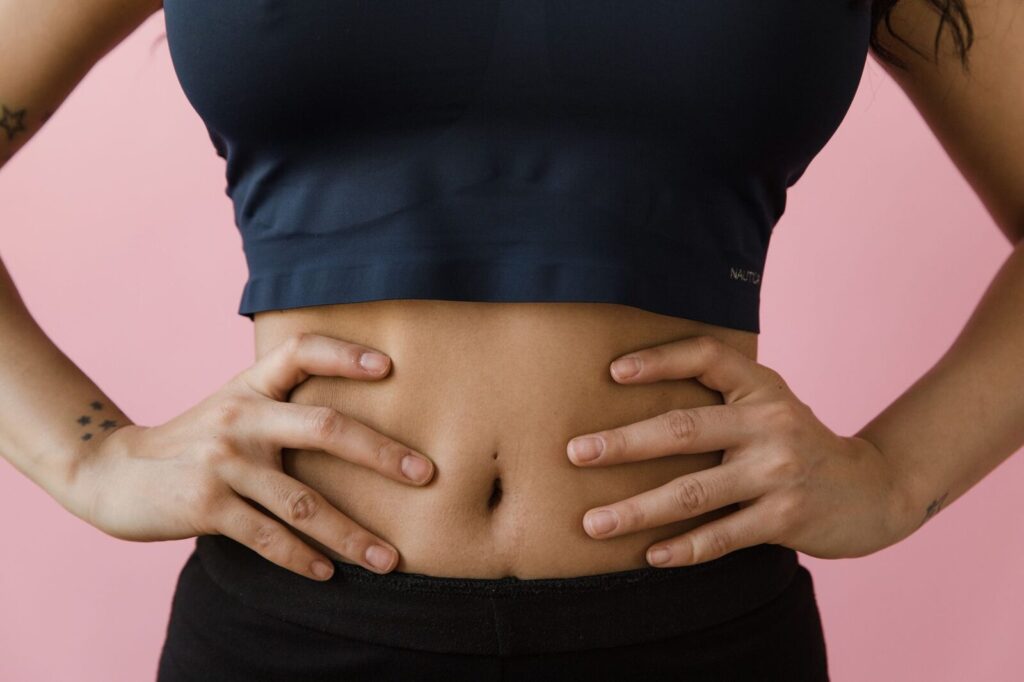 Mains posées sur le ventre, geste de gêne abdominale