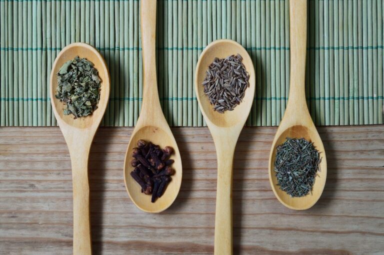 Graines noires de nigelle dans un bol et une cuillère en bois