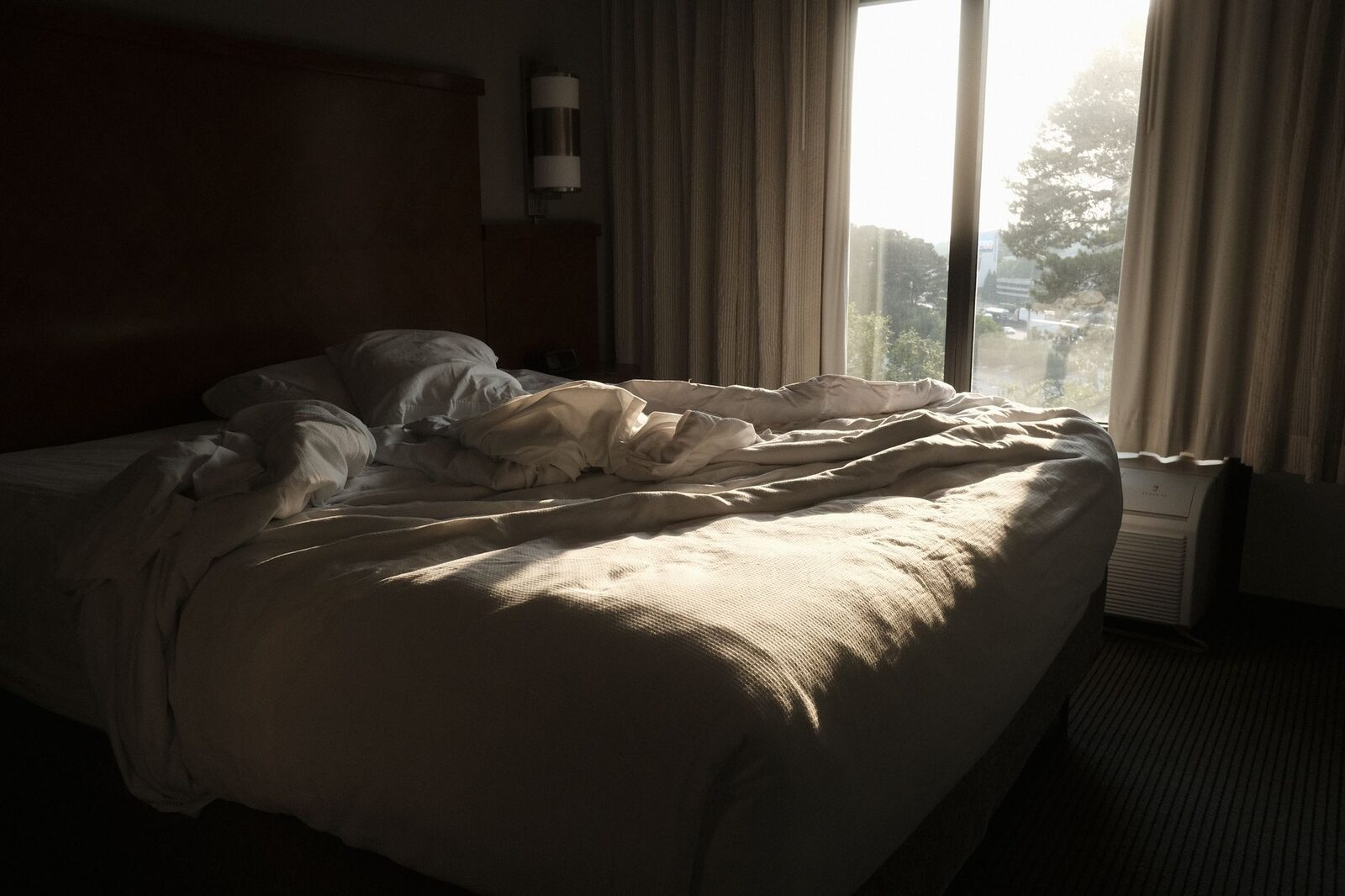 Chambre claire avec lit fait et lumière du matin